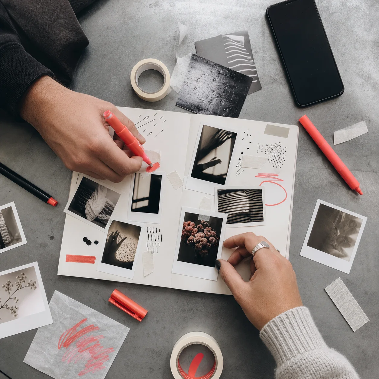 Two adult hands making a playful paper and photo collage together