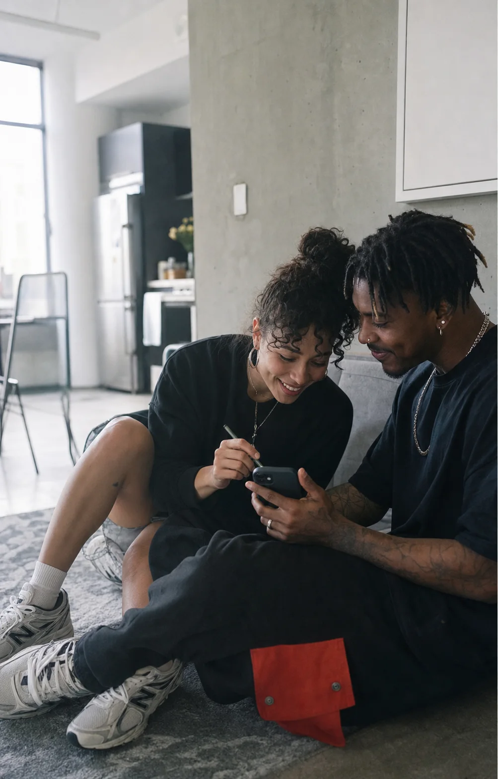 Two adult partners drawing together on a phone at home